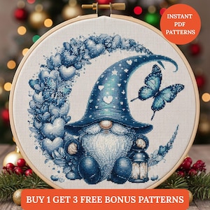 Puede incluir: Un patrón de punto de cruz con un gnomo azul con un gorro puntiagudo, sentado en una luna creciente hecha de corazones. Una mariposa azul está cerca. El texto "INSTANT PDF PATTERNS" y "BUY 1 GET 3 FREE BONUS PATTERNS" son visibles.