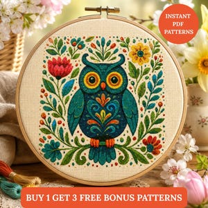 May include: A circular wooden embroidery hoop containing a cross-stitch design of a teal owl surrounded by colorful flowers and foliage on cream-colored fabric. The text INSTANT PDF PATTERNS and BUY 1 GET 3 FREE BONUS PATTERNS is visible.