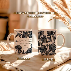 May include: Two ceramic mugs with a black floral pattern on a cream background. The left mug displays the text: A quote you love, styled in a charming vintage typewriter font. -author. The right mug features a dense pattern of black flowers.