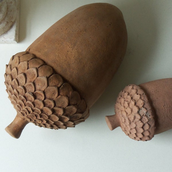 two cement acorns