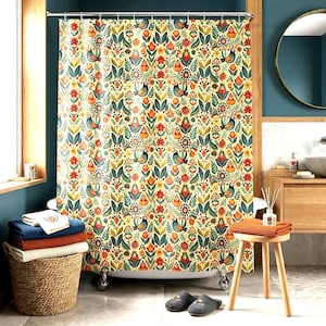 May include: A floral shower curtain with a cream background, featuring a repeating pattern of birds, flowers, and leaves in orange, green, and blue. The curtain hangs in front of a white bathtub with silver feet. A wicker basket holds folded towels.