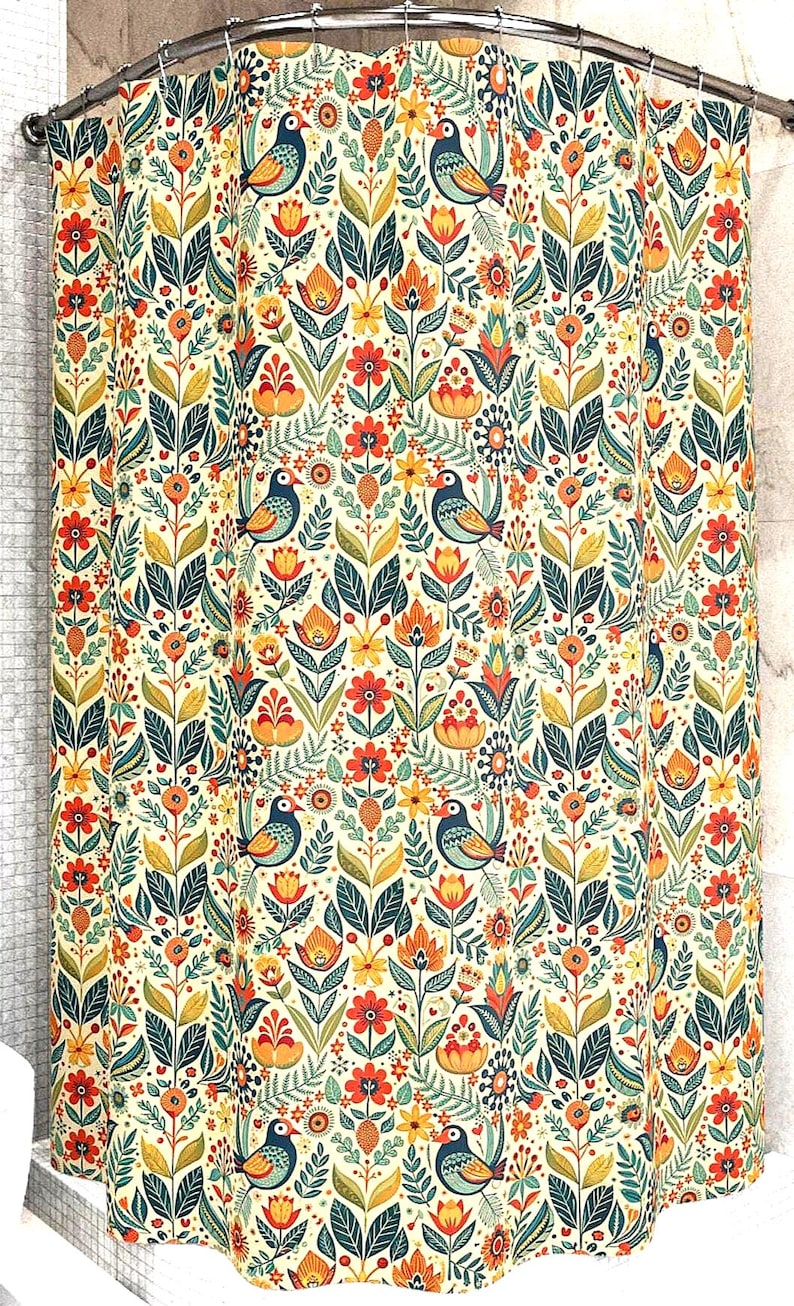 May include: A shower curtain with a repeating pattern of stylized birds, flowers, and leaves in shades of orange, yellow, teal, and green on a cream background. The design has a folk art style, creating a vibrant and decorative bathroom accessory.