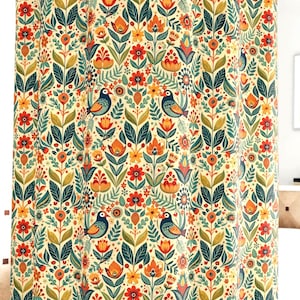 May include: A shower curtain with a repeating pattern of stylized birds, flowers, and foliage in shades of blue, orange, green, and yellow on a cream background. The design has a folk art aesthetic.
