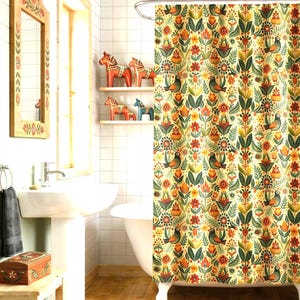 May include: A bathroom scene featuring a floral patterned shower curtain with birds and flowers in shades of orange, green, and yellow. Wooden shelves display decorative wooden horses. A wooden framed mirror and a small wooden box are also visible.