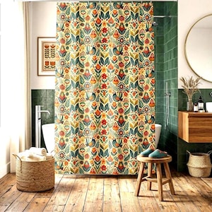 May include: A floral patterned shower curtain with birds, flowers, and leaves in shades of red, orange, green, and blue. The curtain is hanging in a bathroom with a wooden floor and a round mirror.
