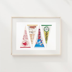 Puede incluir: Impresi&oacute;n enmarcada con cuatro banderines vintage. Los banderines muestran logotipos y nombres de equipos: Boston Red Sox, Boston Bruins, New England Patriots y Celtics. Los banderines son blancos con detalles en rojo, azul, verde y amarillo. El marco es de madera clara.