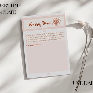 May include: A pink and white "Worry Time" template with text. The top of the template reads "Worry Time" in brown script. The template includes instructions to write down worries for 5-10 minutes daily. The words "USE DAILY" are at the bottom.