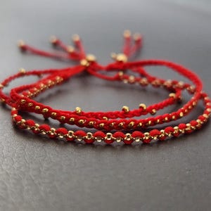 Red String Freundschaftsarmband: Gewebte Kordel mit Goldperlen, Verstellbar