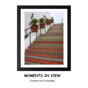 May include: A colorful tiled staircase with a white railing leading up to a white building with a red tile roof. The staircase is decorated with colorful tiles in a geometric pattern.