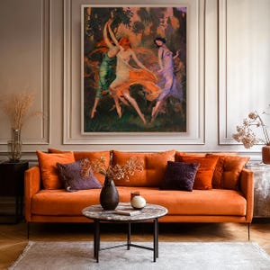 May include: An orange velvet sofa with decorative pillows and a round coffee table. Above the sofa hangs a framed painting of three dancing figures in flowing gowns. The room has a neutral color palette with wood flooring.