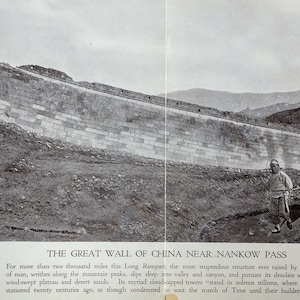 May include: A black and white photograph of the Great Wall of China near Nankow Pass. The wall stretches across a hilly landscape, with a man and several pack animals walking along a path. The text "THE GREAT WALL OF CHINA NEAR NANKOW PASS" is at the bottom.