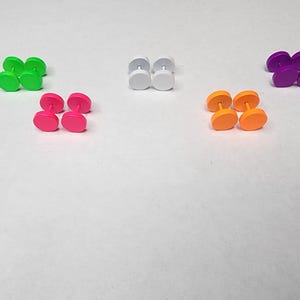 Puede incluir: Un conjunto de ocho medidores de oreja coloridos en verde, rosa, blanco, naranja y morado. Los medidores están hechos de acrílico y están disponibles en una variedad de tamaños.