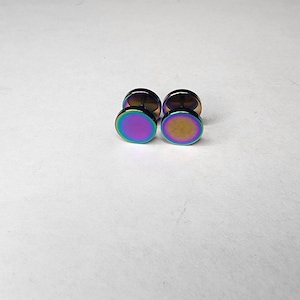 Może przedstawiać: Para iryzujących okrągłych kolczyków z srebrnym zapięciem.