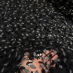 May include: Black mesh fabric with silver sequins in a leaf pattern.