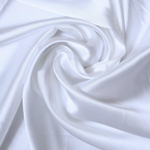 May include: A close-up shot of white satin fabric with soft folds and a lustrous sheen. The fabric is arranged in gentle curves, creating a sense of movement and texture. The overall effect is one of elegance and luxury.