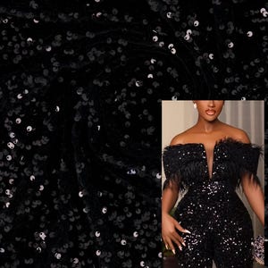 May include: Black sequined fabric with a swirling pattern. The fabric is shown on a model wearing a black sequined jumpsuit with a feather trim.