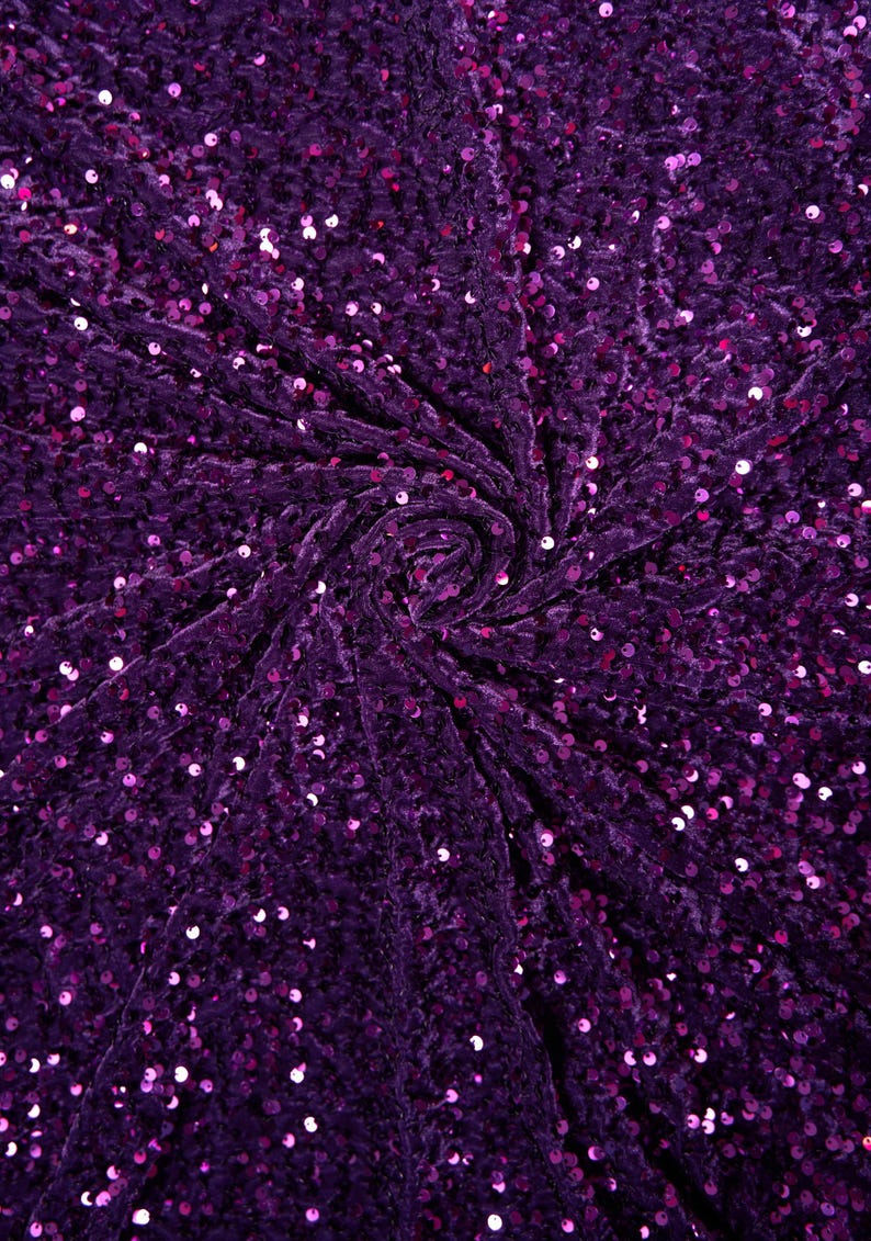 May include: Purple velvet fabric with sequins. The fabric is gathered in the center, creating a swirling pattern.