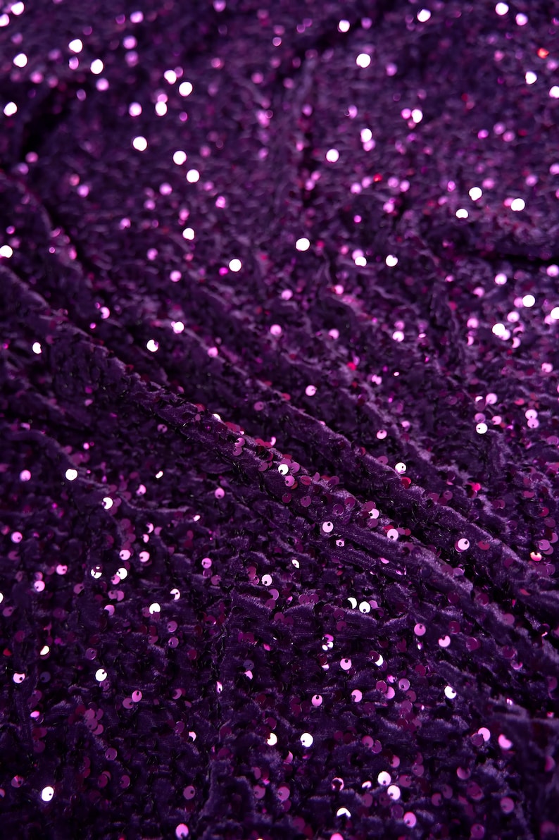 May include: Purple fabric with a textured surface covered in small, iridescent sequins.
