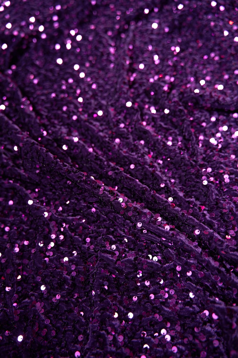 May include: Purple fabric with a textured surface covered in small, round sequins.