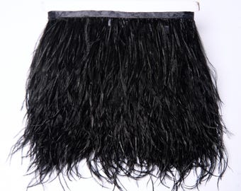 Puede incluir: Borde de plumas de avestruz negras con un respaldo de cinta de satén negro. El borde tiene aproximadamente 15 cm de ancho.