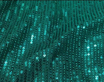 May include: Teal green fabric with a sequins pattern. The sequins are arranged in vertical rows.