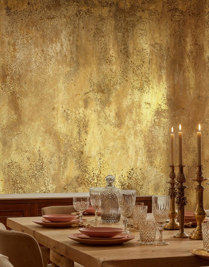 Sophisticated dining room table setting with crystal glassware and classic brass candlesticks. Rustic Grunge Wall Mural in faux gold adding a warm, textured plaster illusion to the dining area.