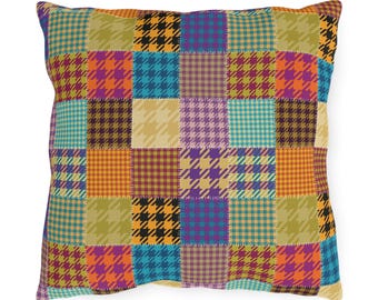 Puede incluir: Una almohada de patchwork colorida con un patrón de pata de gallo en tonos naranja, amarillo, morado, azul y negro.