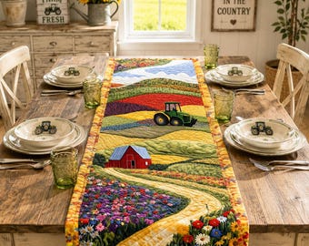 May include: A rectangular quilted table runner featuring a vibrant landscape scene with a red barn, a green tractor, rolling hills, and colorful wildflowers. The design includes a winding yellow path, blue sky, and a yellow border on a wooden table.