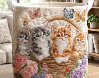 May include: Cream-colored storage basket with a quilted design featuring four kittens in a woven basket, surrounded by embroidered flowers and butterflies. The basket has white handles.