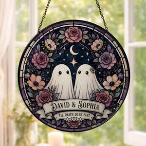 Op de afbeelding: Een ronde glas-in-lood suncatcher met twee witte geesten omringd door roze en paarse rozen tegen een donkere sterrenhemel met een maansikkel. Een banner onderaan toont de tekst David & Sophia en Til Death Do Us Part.