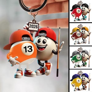 May include: A keychain featuring two cartoon billiard balls wearing baseball caps and sneakers. One is orange with the number 13 and the name "William", the other is white with the name "Jennifer". A small tag reads "2026". Additional images show other billiard ball characters.