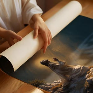 K&ouml;nnte beinhalten: Ein aufgerollter Leinwanddruck eines Gem&auml;ldes, das einen Mann in einem wei&szlig;en Gewand zeigt, der auf einem felsigen H&uuml;gel kniet und seine H&auml;nde zum Gebet erhoben hat. Der Himmel hinter ihm ist eine dramatische Mischung aus Dunkelblau und goldenem Licht.
