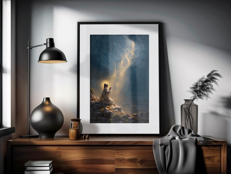 K&ouml;nnte beinhalten: Ein gerahmter Druck eines Gem&auml;ldes, das eine Person im Gebet kniend zeigt, mit einem hellen Licht, das vom Himmel herabscheint. Das Gem&auml;lde ist vor einem dunkelblauen Hintergrund mit Wolken platziert.