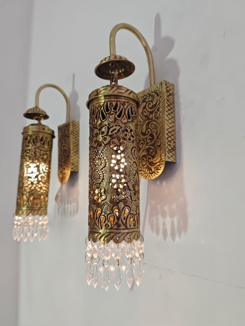 Ornate brass wall sconce with pierced metal shade and crystals