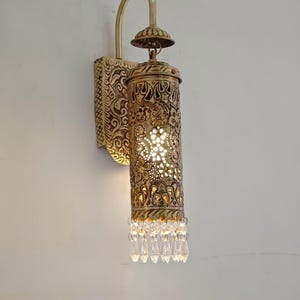 Traditional carved brass wall lantern with warm ambient glow effect