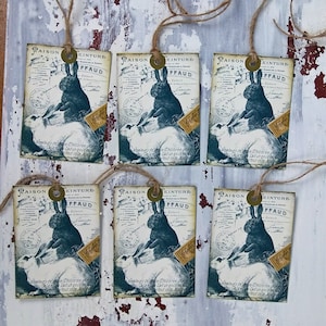 May include: Six vintage-style gift tags with a white background and black and blue illustrations of rabbits. The tags feature the text "Maison d'Einture" and "FFAUD" in a decorative font.