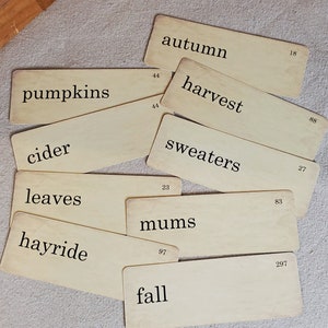 May include: A set of vintage-style cards with autumn-themed words like "autumn", "harvest", "sweaters", "pumpkins", "cider", "leaves", "mums", "hayride", and "fall".