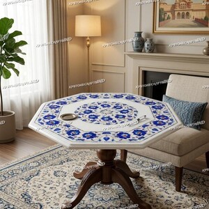 May include: White marble octagonal table with intricate blue floral inlay. The table has a dark brown wooden pedestal base and is set in a room with a patterned rug and a beige armchair. A small decorative tray sits on the table.