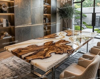 May include: A striking dining table with a white epoxy resin surface, incorporating natural wood grain and gold details. The table, approximately 240 cm long, sits on a polished metal base. Beige upholstered chairs surround the table, creating an elegant dining setting.