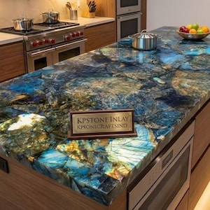 Könnte beinhalten: Kücheninsel mit einer Arbeitsplatte mit auffälligem blauem, grünen und goldenen Muster. Die Arbeitsplatte besteht aus einem einzigartigen Stein mit polierter Oberfläche. Die Insel hat einen Holzsockel und einen Einbauofen. Ein Schild liest "KPSTONE INLAY".