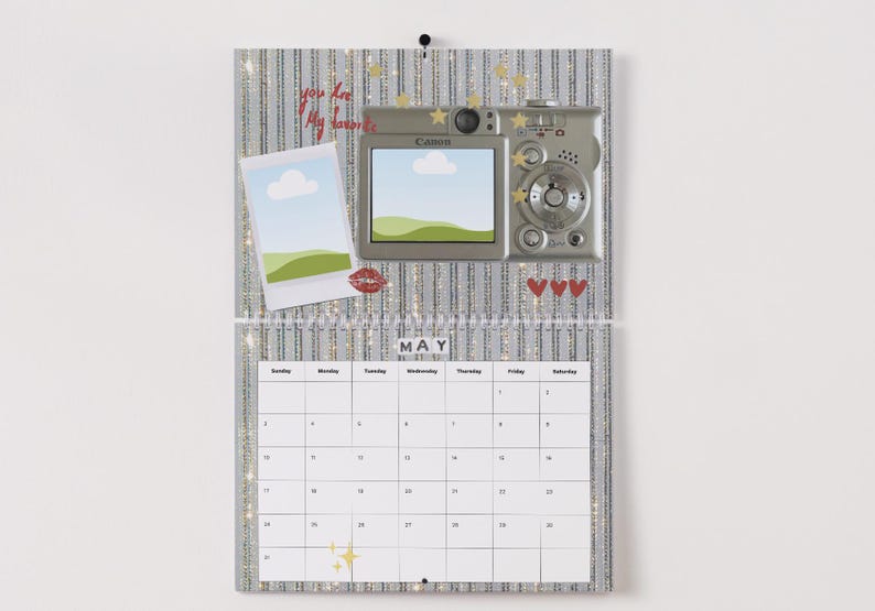 May include: A decorative calendar with a silver glitter background, featuring a digital camera, a polaroid-style photo, and the text "You are My Favorite." The calendar displays the month of May.