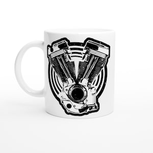 Può includere: Tazza in ceramica bianca con un'illustrazione in bianco e nero di un motore di motocicletta. Il motore è l'elemento centrale del design, posto su un motivo circolare. La tazza ha un manico curvo sul lato sinistro.
