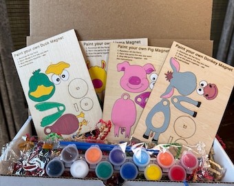 May include: A cardboard box containing four wooden craft kits labeled Paint your own Duck Magnet, Llama Magnet, Pig Magnet, and Donkey Magnet. Each kit includes laser-cut wooden pieces and a plastic strip of twelve small paint pots and a brush.