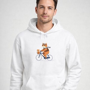 May include: White hoodie featuring a cartoon fox riding a bicycle with a smaller fox in the basket. The fox wears goggles and a scarf. The design is centered on the front of the hoodie.
