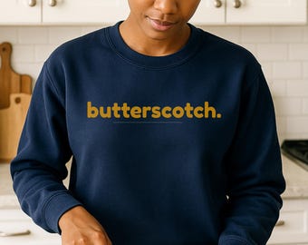 May include: Navy blue sweatshirt with the word "butterscotch." printed in gold lettering across the chest. The sweatshirt is a crew neck style and appears to be made of a soft material.