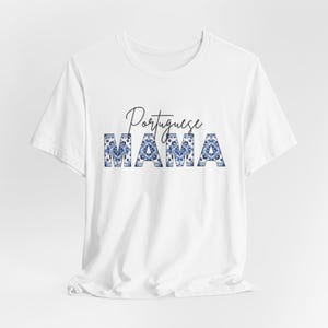 Könnte beinhalten: Weißes T-Shirt mit dem Text "Portuguese Mama" in schwarzer Schrift. Das Wort "Mama" ist mit einem blau-weißen Muster verziert.