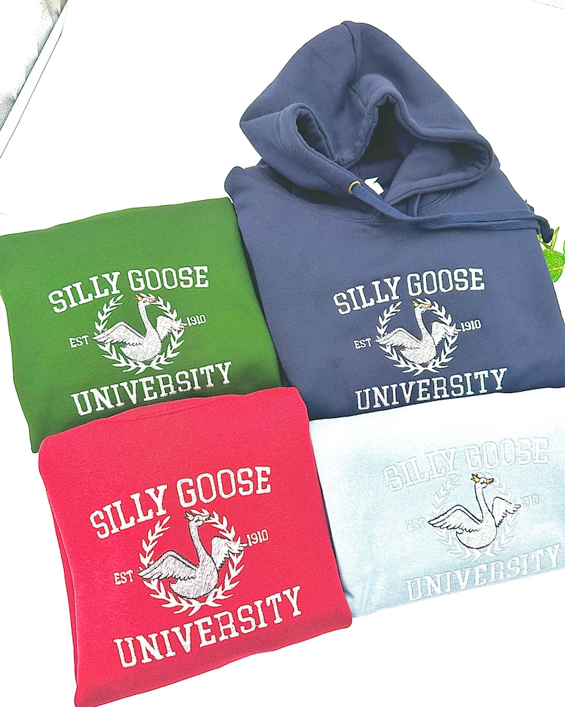 May include: Four hooded sweatshirts in different colors: green, blue, red, and light blue. Each sweatshirt features a white embroidered logo with the text "Silly Goose University" and a swan design.