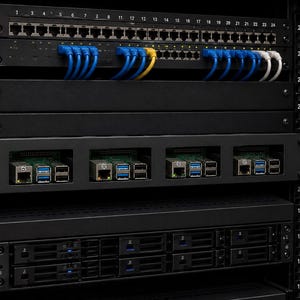 May include: A black server rack cabinet containing a 24-port network switch with blue, yellow, and white ethernet cables connected. Below is a rack-mount chassis holding four single-board computers, followed by a server unit with multiple drive bays.