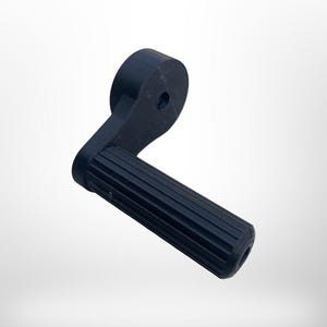 May include: A black, L-shaped handle with a ridged grip. The handle has a rounded end and a circular hole near the top. The object appears to be made of a solid, matte material.