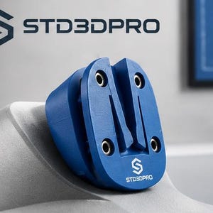 以下が含まれることがあります： STD3DPROのロゴ、中央の垂直スロット、4つの金属製取り付け穴を備えた青い3Dプリント部品。このオブジェクトは、マット仕上げの丸みを帯びたコンパクトな形状で、STD3DPROというテキストが刻印されています。